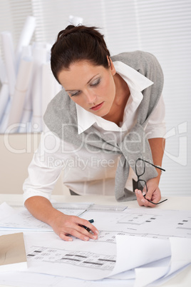 Female architect watching plans