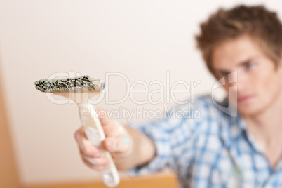 Home improvement: Young man holding paint brush