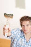 Home improvement: Young man holding paint brush