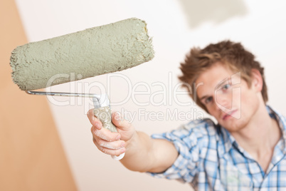 Home improvement: Young man holding paint roller