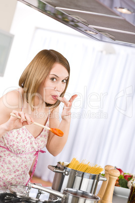 Cooking - Young woman tasting Italian tomato sauce