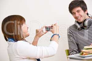 Students - happy teenage couple taking photo with camera