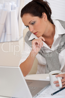 Female architect with laptop and coffee sitting