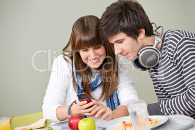 Student cafeteria - teenage couple with mobile phone
