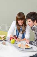 Student cafeteria - teenage couple with mobile phone