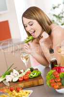 Cooking - happy woman biting slice of green pepper
