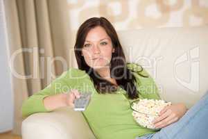 Woman watching television with popcorn in living room