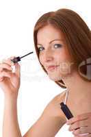 Body care series - Smiling red hair woman applying mascara