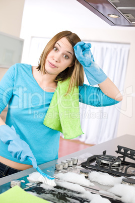 Cleaning - Tired woman cleaning stove in modern kitchen