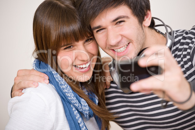 Students - happy teenage couple taking photo with camera