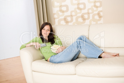 Woman watching television with popcorn in living room