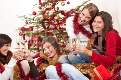 Four smiling women with glass of champagne on Christmas