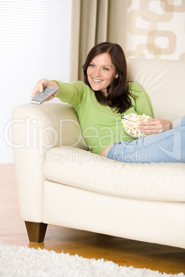 Woman pointing with television remote control