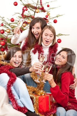 Four young woman toasting with champagne on Christmas