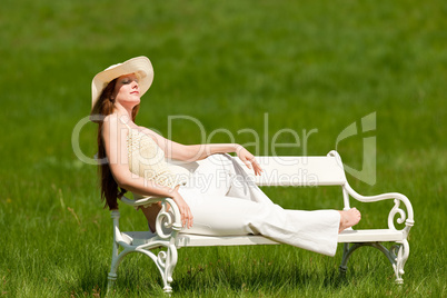 Red hair woman sitting on white bench in spring