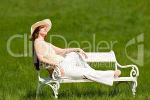 Red hair woman sitting on white bench in spring