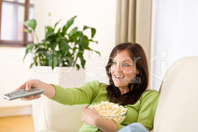 Woman watching television with popcorn in living room