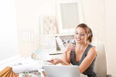 Young female designer working at office with laptop