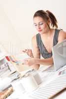 Young female designer working at office with laptop