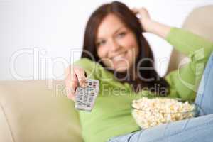 Woman watching television with popcorn in living room