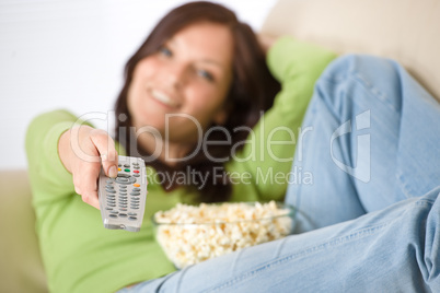 Woman watching television with popcorn in living room