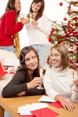 Four smiling women with glass of champagne on Christmas