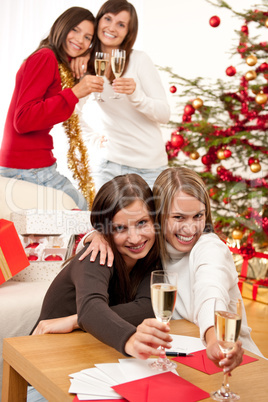 Four smiling women with glass of champagne on Christmas