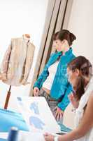 Fashion model trying turquoise jacket in designer studio