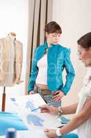 Fashion model trying turquoise jacket in designer studio