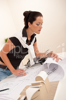 Attractive female architect watching plans
