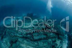 Female scuba diver over ship wreckage