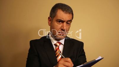 Businessman writing document on clipboard