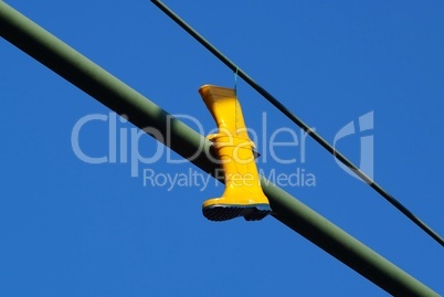 Gelbe Gummistiefel hängen an einem Straßenmast