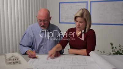 A man and woman go over architecture plans, dolly shot