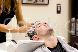 Attractive man having a shampoo