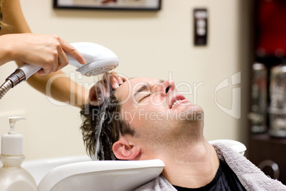 Cute man having his hair washed