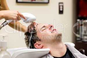 Cute man having his hair washed