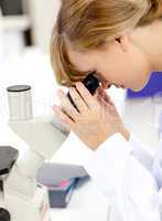 female scientist looking through a microscope
