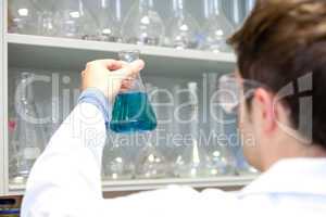 Young scientist looking at an erlenmeyer