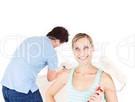 Positive couple painting a room