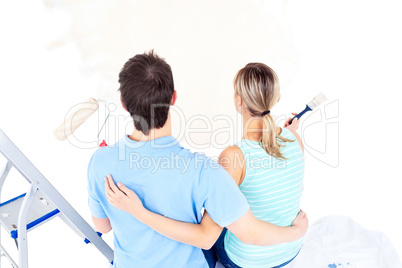 Affectionate couple painting a room