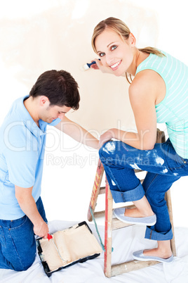 Beautiful couple painting a room