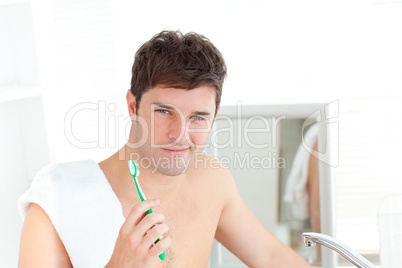 man with a towel brushing his teeth