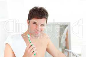 man with a towel brushing his teeth