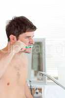 man brushing his teeth in the bathroom