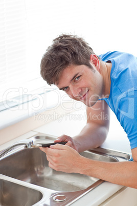 man repairing his sink in the kitchen