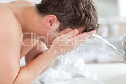 man spraying water on his face