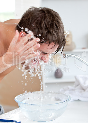 man spraying water on his face