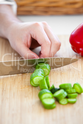 man cutting a cucumber in the kitchen