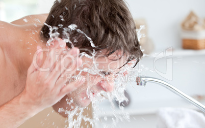 man spraying water on his face